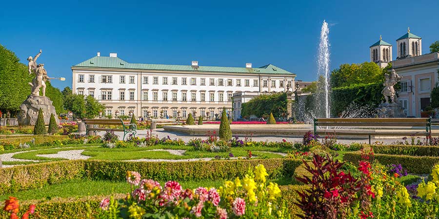 The beautiful Mirabell Gardens feature vibrant flowers, ornate sculptures and a fountain. 